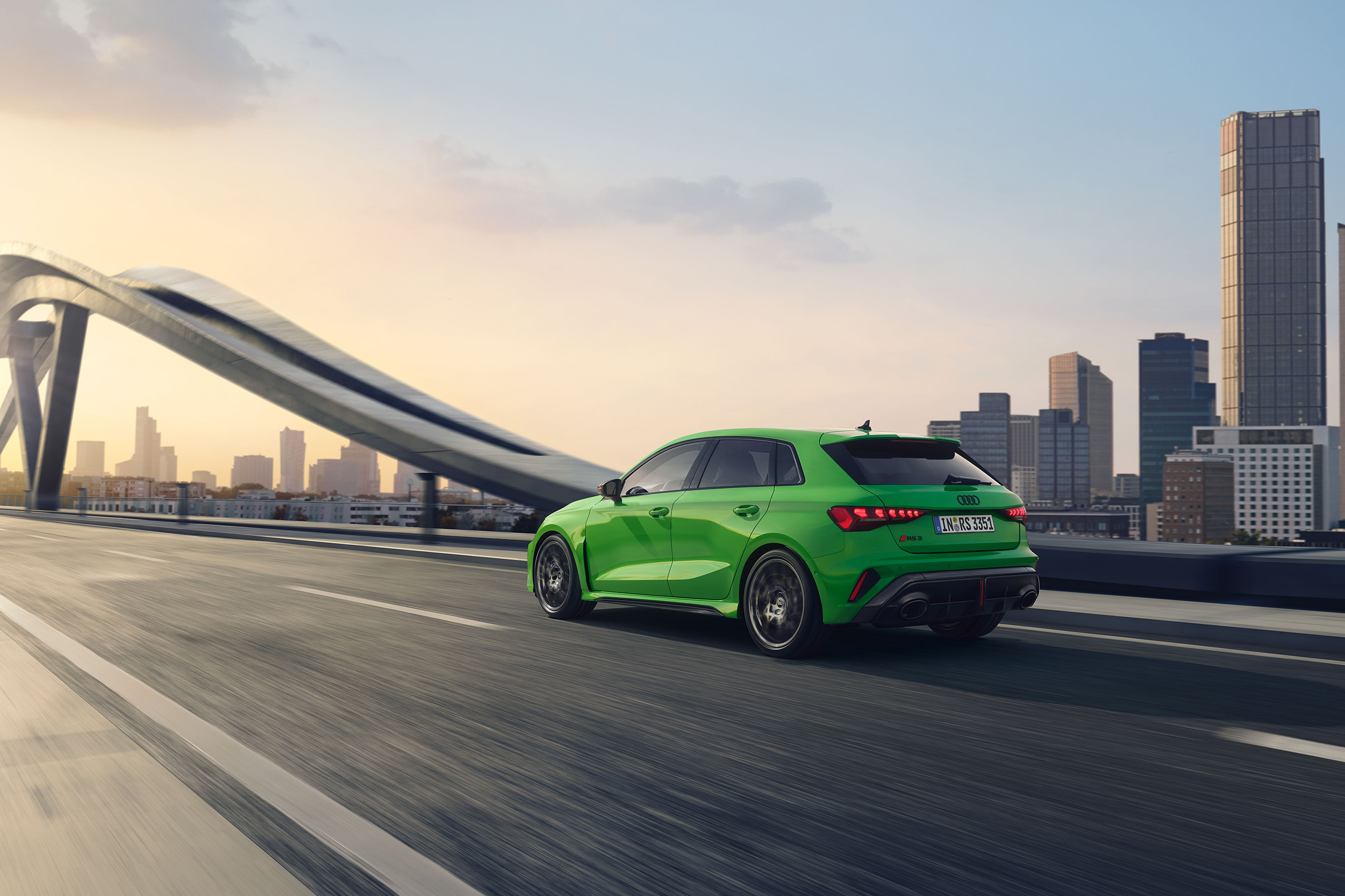 Ein gr&uuml;ner Audi RS 3 Sportback in Heck-Seitenansicht der grade &uuml;ber eine Br&uuml;cke f&auml;hrt