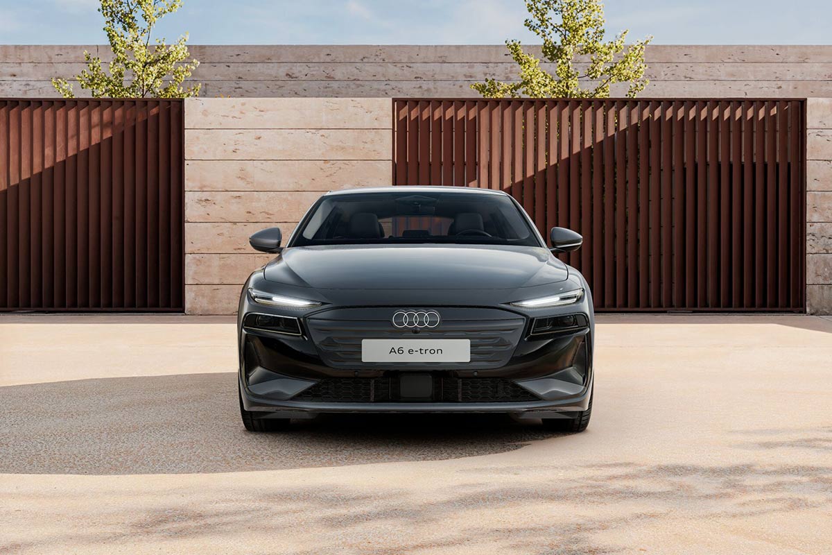 Ein grauer Audi A6 Avant e-tron Frontansicht geparkt vor einer modernen Hausfront