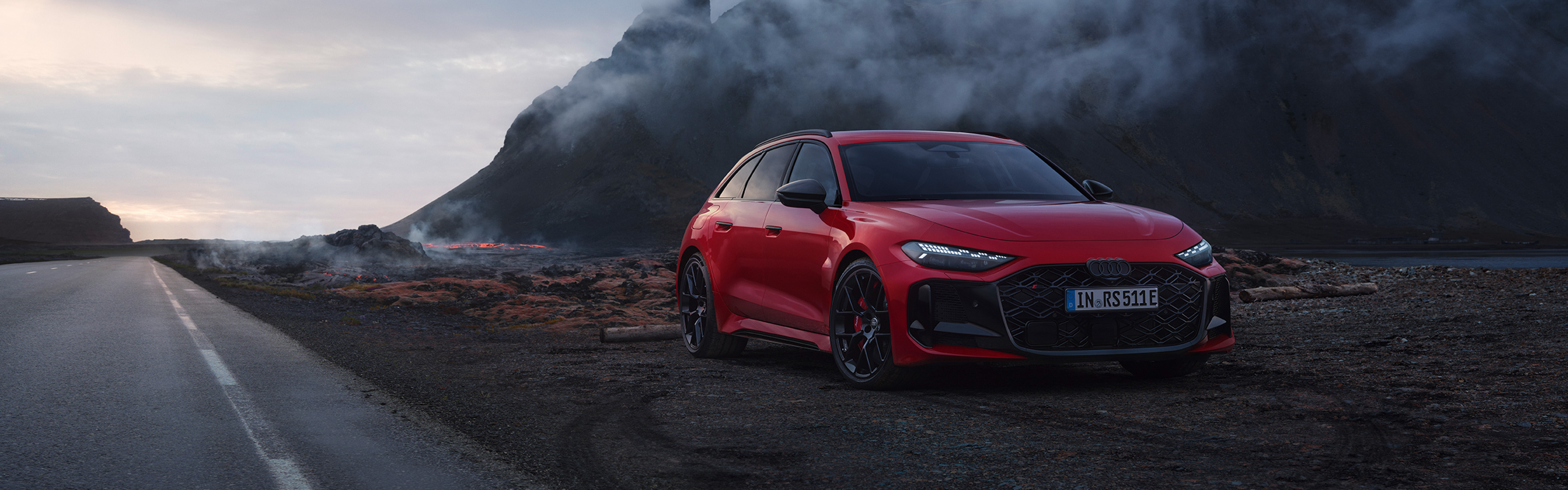 Audi RS 5 Avant, rot, Frontansicht, parkend neben Stra&szlig;e mit Bergen im Hintergrund